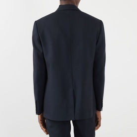 Model wearing Valentino storm blue virgin wool blazer, rear view showing single vent and button cuffs, styled with matching trousers