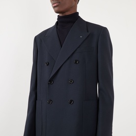 Model wearing Valentino storm blue wool double-breasted blazer with dark buttons, styled with a black roll-neck jumper.
