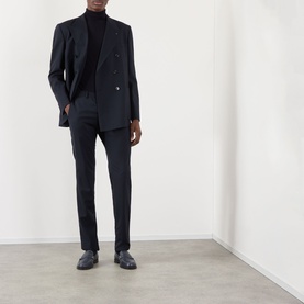 Model wearing Valentino storm blue wool blazer, styled with matching trousers, black turtleneck, and dark leather loafers