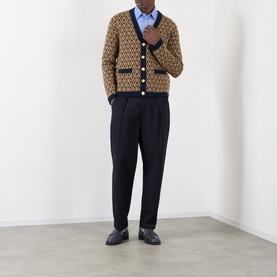 Model wearing Valentino camel wool cardigan with geometric jacquard pattern, styled with blue shirt, black trousers and loafers.