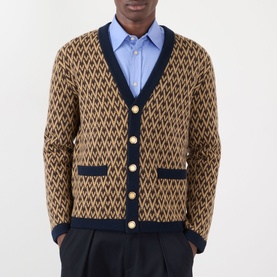 Model wearing Valentino camel virgin wool cardigan with navy diamond jacquard pattern, gold buttons, and V-neck trim, styled with blue shirt