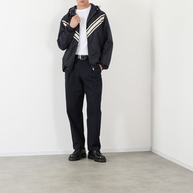 Model wearing Valentino dark marine and beige casual jacket with chevron stripes, styled with black trousers and chunky leather shoes