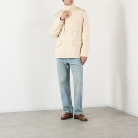 Model wearing Valentino sea shell cotton casual jacket with chest pockets, styled with light blue jeans and brown loafers.