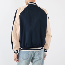 Model wearing Valentino navy casual jacket, back view, contrast beige sleeves, ribbed collar, cuffs and hem, styled with light blue jeans