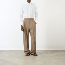 Model wearing Valentino Tonal Embroidered White Shirt with point collar, styled with taupe wide-leg trousers and brown sandals.