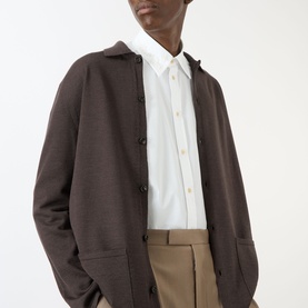 Model wearing Valentino Tonal Embroidered Shirt in white with point collar, styled with dark brown cardigan and taupe trousers.