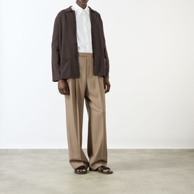 Model wearing Valentino Tonal Embroidered White Shirt with brown jacket, taupe wide-leg trousers and brown sandals.