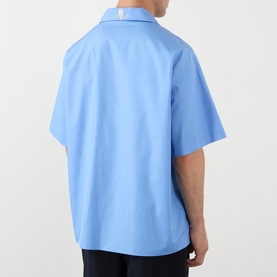 Model wearing Valentino Camica Maniche Bowling Casual Shirt in Celeste Denim, short-sleeve relaxed fit, rear view, paired with black trousers.