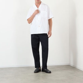 Model wearing Valentino white cotton short-sleeve casual shirt with chest pocket, styled with black trousers and loafers.