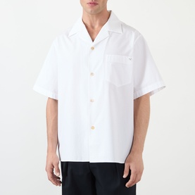 Model wearing Valentino white cotton casual shirt with open camp collar, short sleeves, chest pocket, and gold-tone buttons