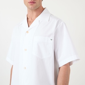 Model wearing Valentino white cotton casual shirt with open camp collar, short sleeves, chest pocket and VLogo embroidery detail