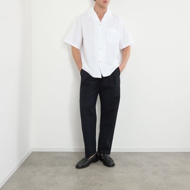 Model wearing Valentino white short-sleeve casual shirt in 100% cotton, styled with black trousers and black loafers.