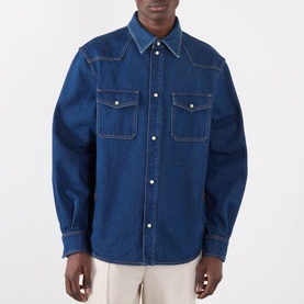Model wearing Valentino medium blue denim casual shirt with twin chest pockets, contrast stitching and snap buttons, styled with cream trousers.