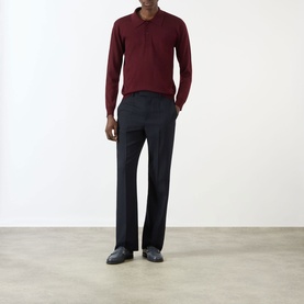 Model wearing Valentino Logo Knitted Polo Sweater in red with navy tailored trousers and dark loafers.