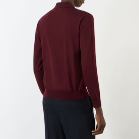 Model wearing Valentino Logo Knitted Polo Sweater in red, back view, with navy trousers. Ribbed trims, long sleeves, straight hem.