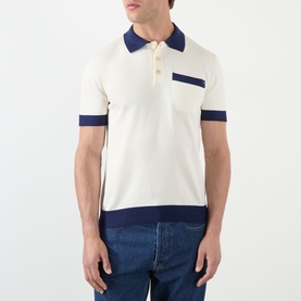 Model wearing Valentino cream cotton polo shirt with navy collar, cuffs and hem contrast trim, chest pocket, paired with blue jeans