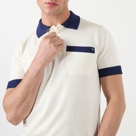 Model wearing Valentino cream cotton polo shirt with navy collar, chest stripe, and ribbed cuffs, with VLogo detail on pocket