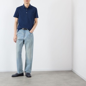 Model wearing Valentino indigo cotton polo shirt, styled with light-wash straight-leg jeans, black belt and dark loafers