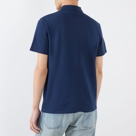 Model wearing Valentino indigo cotton polo shirt, rear view, styled with light-wash jeans