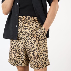 Model wearing Valentino Multicolor Animalier silk shorts with leopard print, styled with a black short-sleeve shirt
