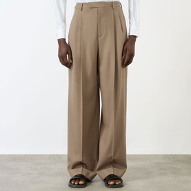 Model wearing Valentino Pleated Straight-Leg Trousers in camel wool, high-rise with pressed creases and turn-up hems, styled with white shirt and