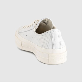 Converse low-top trainer in vintage white perforated leather, rear three-quarter view, cream flatform sole.