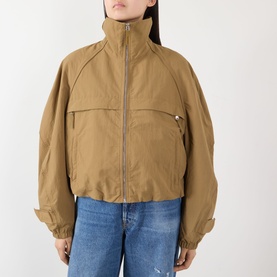 Model wearing Acne Logo Technical Bomber Jacket in dark khaki with funnel neck, front zip and large zip pockets, styled with blue jeans.