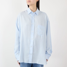 Model wearing Acne blue striped oversized shirt in lyocell, featuring chest patch pocket, classic collar and relaxed long sleeves