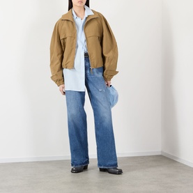 Model wearing Acne blue lyocell shirt, styled with camel cropped jacket, wide-leg jeans and black loafers