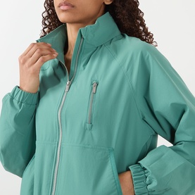 Model wearing Adanola Eucalyptus Green jacket with silver zip detail, chest pocket, and elasticated cuffs, close-up view.
