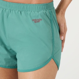 Model wearing Adanola Sport shorts in Eucalyptus Green, elasticated waistband, curved hem detail, close-up view.