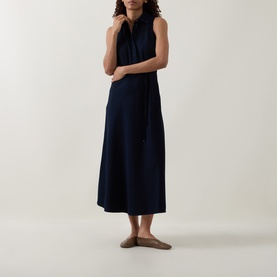 Model wearing Luisa Cerano Dark Blue Denim Shirt Dress; sleeveless midi with pointed collar, tie waist belt and flared skirt, styled with nude flat