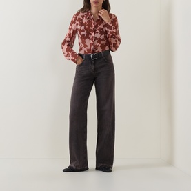 Model wearing Luisa Cerano wide-leg dark grey jeans with black belt, styled with a pink floral blouse and black flats.
