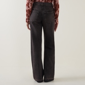 Model wearing Luisa Cerano wide-leg dark grey jeans, rear view, styled with a floral print blouse.