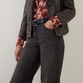 Model wearing Luisa Cerano jeans in dark grey wash, styled with a brown tweed blazer, floral top, and black belt.