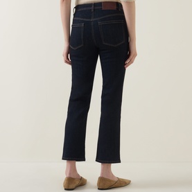 Model wearing Luisa Cerano Straight Leg Jeans in dark blue with tobacco stitching, styled with tan loafers. Rear view.