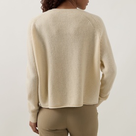 Model wearing Luisa Cerano Fine Knit Sweater in yellow, rear view showing raglan sleeves, crew neck, dipped hemline, styled with tan trousers.