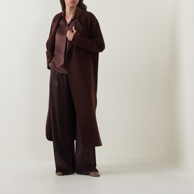 Model wearing Luisa Cerano dark brown silk shirt, styled with matching wide-leg trousers and long brown coat.