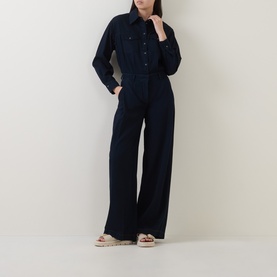 Model wearing Luisa Cerano dark blue wide-leg cotton trousers, styled with a matching dark blue shirt and neutral sandals.