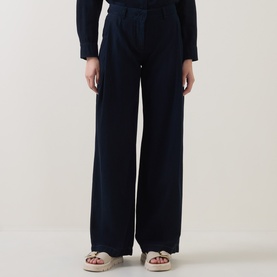 Model wearing Luisa Cerano dark blue wide-leg cotton trousers with pleat detail, styled with beige strappy flat sandals