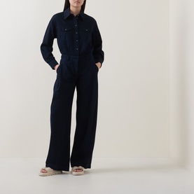 Model wearing Luisa Cerano Dark Blue wide-leg cotton trousers, styled with matching dark blue shirt and neutral sandals.