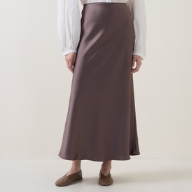 Model wearing Luisa Cerano olive satin midi skirt with flared hem, styled with white blouse and flat loafers.