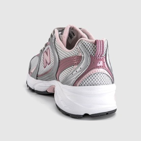 New Balance trainer in silver metallic and rosewood, rear three-quarter view showing N logo, mesh upper, and white chunky sole.