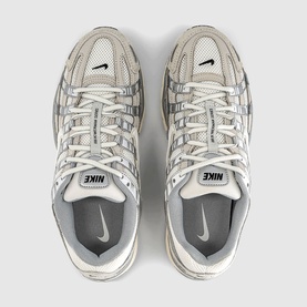 Nike trainers in light bone and sail, overhead flat lay showing mesh upper, chunky sole and dual Nike heel branding