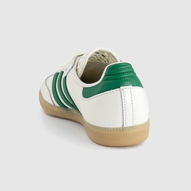 Adidas Samba trainer in off-white leather with green three-stripe detail and heel tab, gum rubber sole, rear angle view