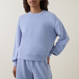 Model wearing Sweaty Betty Laguna Blue sweatshirt, styled with matching wide-leg sweatpants in the same colour