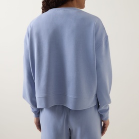Model wearing Sweaty Betty Laguna Blue hoodie, back view, cropped relaxed fit, styled with matching wide-leg joggers