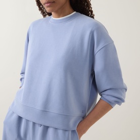 Model wearing Sweaty Betty Laguna Blue sweatshirt with matching wide-leg sweat shorts in the same colourway