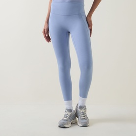 Model wearing Sweaty Betty leggings in Laguna Blue Marl, styled with white ankle socks and grey trainers