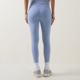 Model wearing Sweaty Betty leggings in Laguna Blue Marl, rear view, styled with white socks and grey trainers.